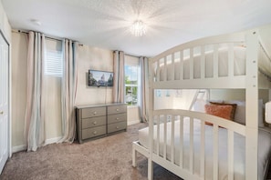 A child's bedroom with bunk beds, a dresser, and a window with curtains. - Private Pool+Spa*Games Room*Clubhouse Amenities (Kissimmee)