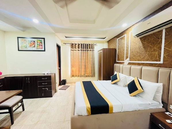 A hotel room with a bed, desk, and wardrobe.