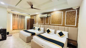 Une chambre d’hôtel avec deux lits, un ventilateur de plafond, un appareil de climatisation et une fenêtre avec des rideaux.