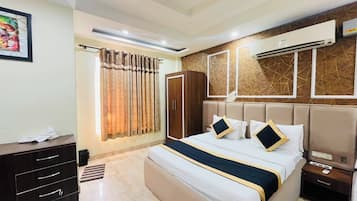 Une chambre d’hôtel comprenant un lit, des tables de chevet, une armoire, une fenêtre avec des rideaux et un appareil de climatisation.