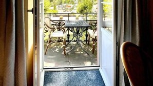 Puerta abierta que da a un patio exterior con una mesa y sillas.