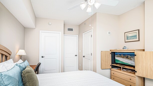 Una habitación de hotel con cama, televisión, escritorio y silla.