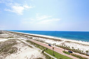Eine Küstenstraße mit Strand auf der einen Seite und blauem Himmel darüber.