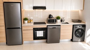 A modern kitchen with stainless steel appliances, including a refrigerator, oven, dishwasher, and washing machine. - Lovely 1-bedroom apartment in Waterfall Midrand. (Waterfall, Midrand)