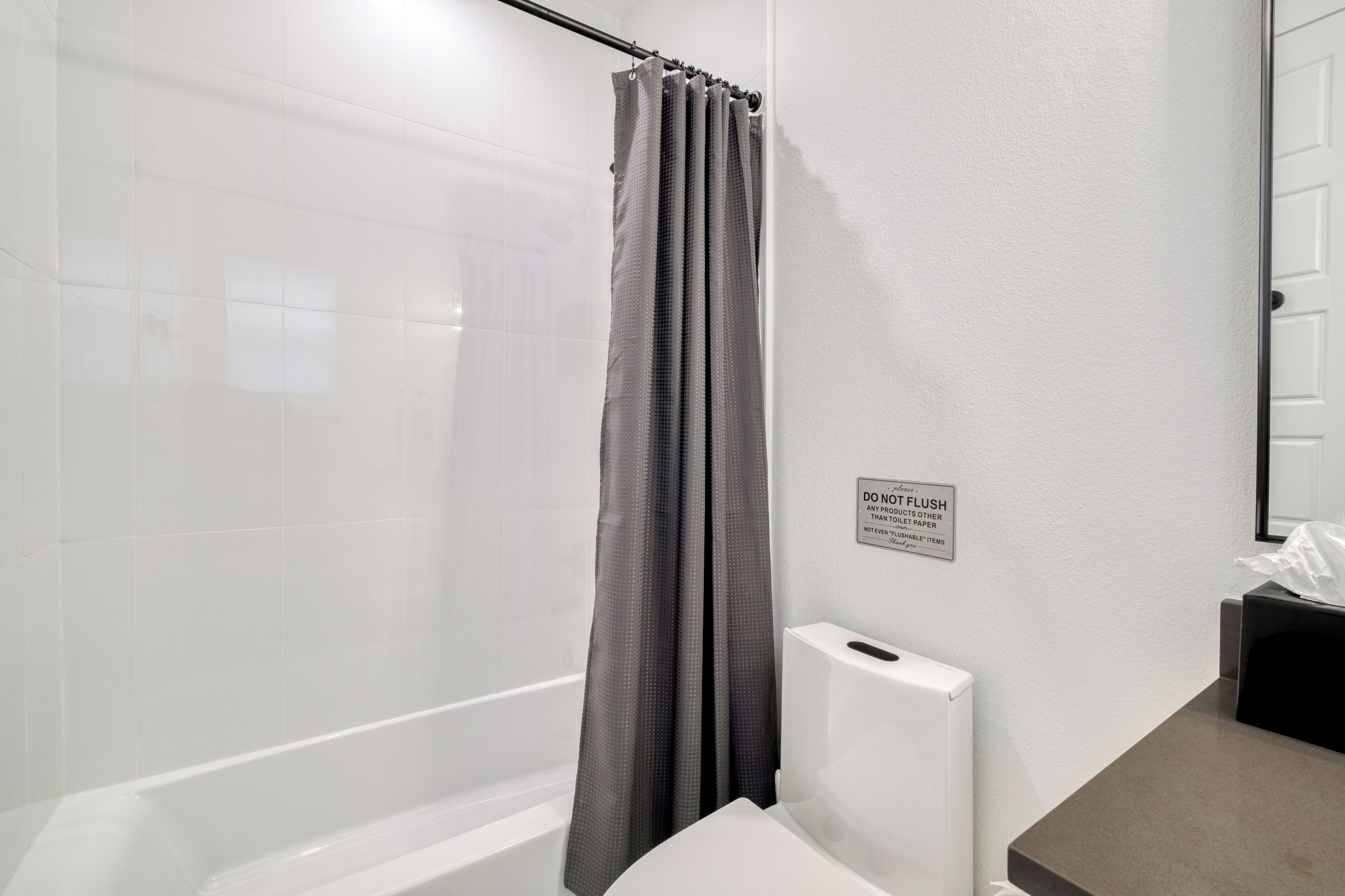 Une salle de bain équipée d’une douche, de toilettes et d’un sèche-mains.