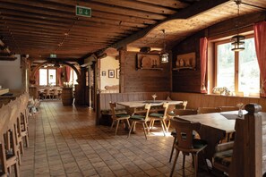 A rustic wooden interior with a long dining area, benches, and a high ceiling. - Berggasthaus Höllensteinhütte (Tux)
