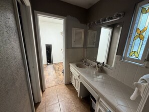Ein Badezimmer mit einem Doppelwaschbecken, einem Spiegel über dem Waschbecken und einer Duschkabine.