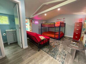 Ein Zimmer mit Etagenbetten, einem kleinen Schreibtisch und einem Schrank.
