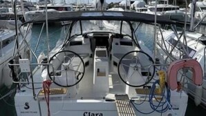 En småbåtshamn där en båt vid namn ”Clara” ligger förtöjd. Båten har ett ratt, vinschar och en livboj.