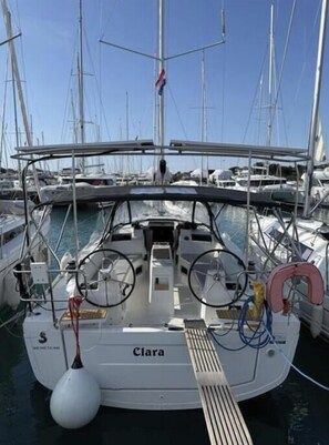 A marina with a boat named 'Clara' docked, featuring a steering wheel, winches, and a lifebuoy. - Oceanis 34.1 - Clara (Bibinje)