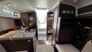 A compact RV interior with a kitchenette, a dining area, and a small living space.