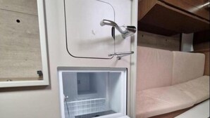 Kompakti ja moderni kylpyhuone, jossa on suihku, pieni pesuallas ja wc.