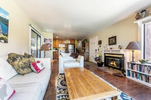 Ein Wohnzimmer mit einer Couch, einem Couchtisch, einem Kamin und einem Bücherregal.