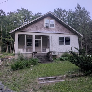 A two-story house with a porch, a chimney, and a number '215' on the front.
