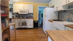 Eine Küche mit weißen Schränken, einer Mikrowelle, einem Backofen und einem Kühlschrank.