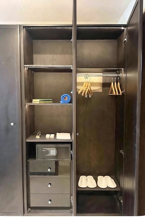 A walk-in closet with shelves, a hanging rack, and a shoe rack. - Elaf Al Sagryah (Makkah)