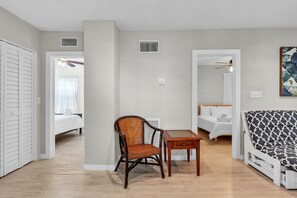 Une pièce comprenant un lit, une chaise, une table, un canapé et un ventilateur de plafond.