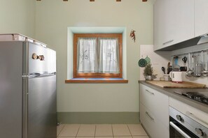 Frigorífico, placa de cocina y utensilios de cocina