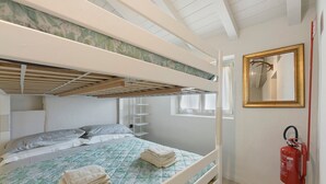 A bunk bed room with a fire extinguisher, a mirror, and a window.