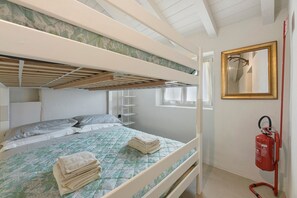 A bunk bed room with a fire extinguisher, a mirror, and a window.