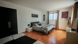A bedroom with a bed, nightstand, and a wardrobe.