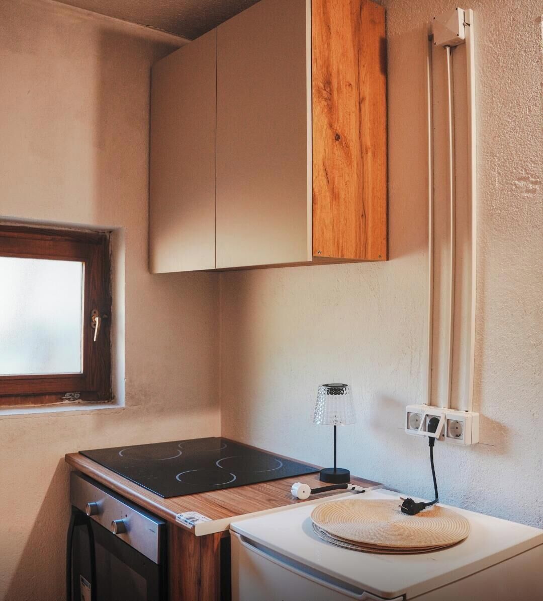 A compact kitchenette with a stove, oven, and a small countertop.