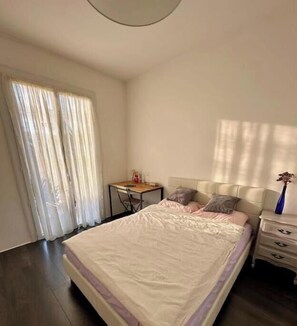 Une chambre à coucher avec un lit, un bureau et une table de chevet.