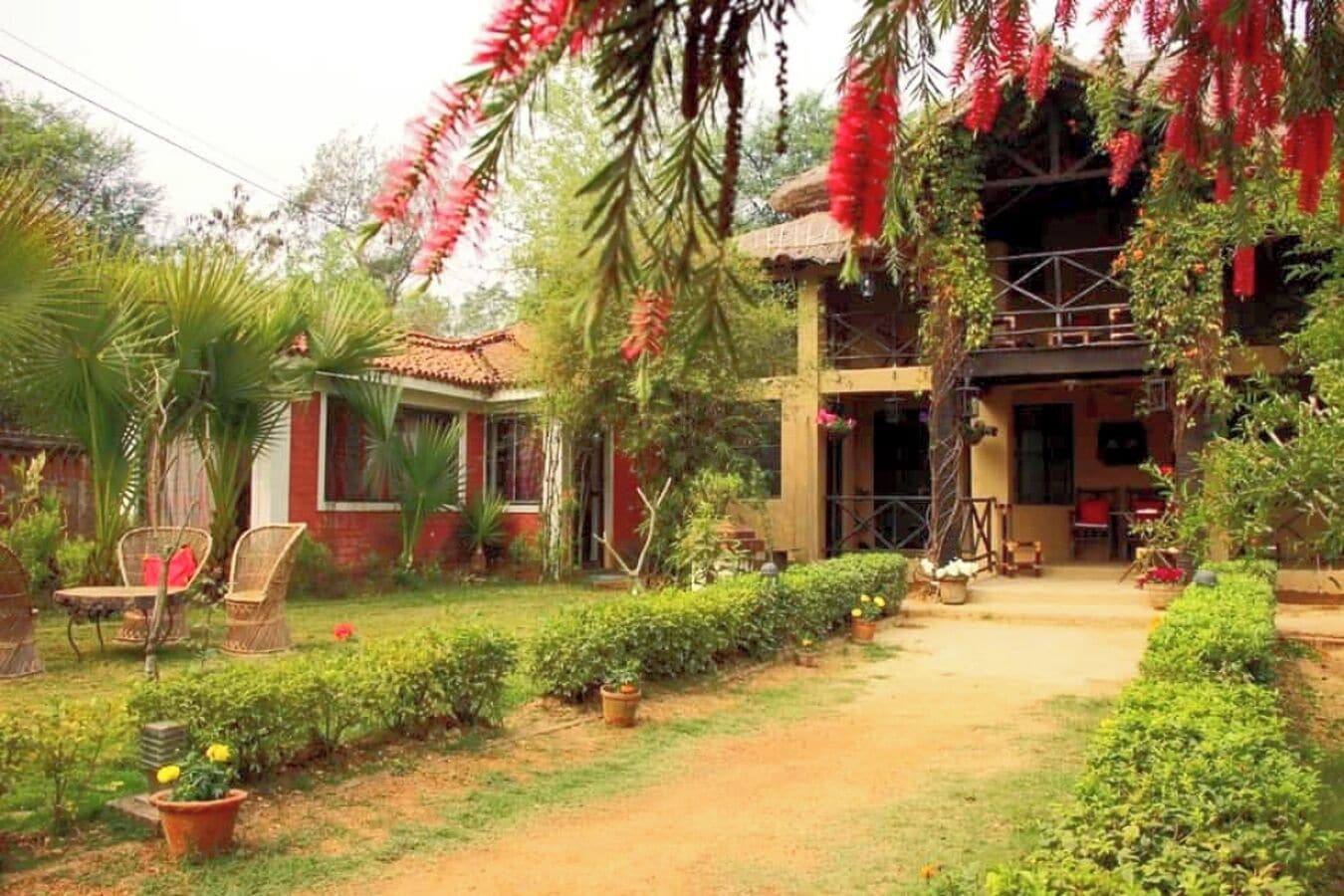 Una casa con jardín, fachada de ladrillo rojo y tejado de paja.