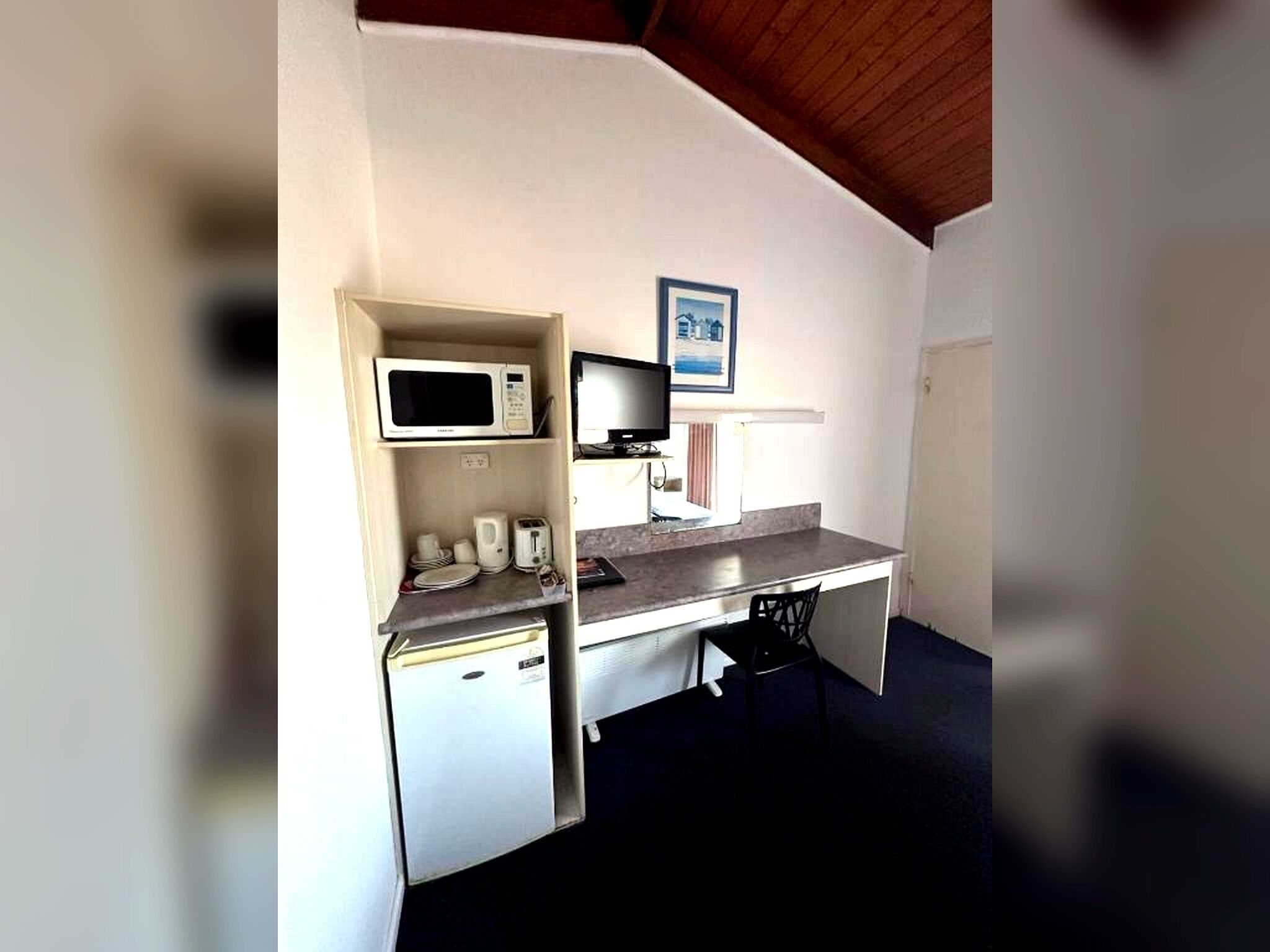 A compact kitchenette with a microwave, toaster, and small refrigerator.