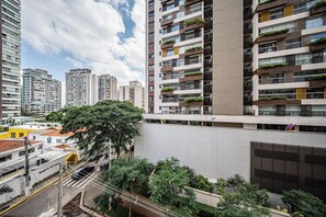 A modern high-rise building with multiple floors, balconies with greenery, and a clear view of the surrounding urban area. - LA CASA PÁSSAROS (São Paulo)
