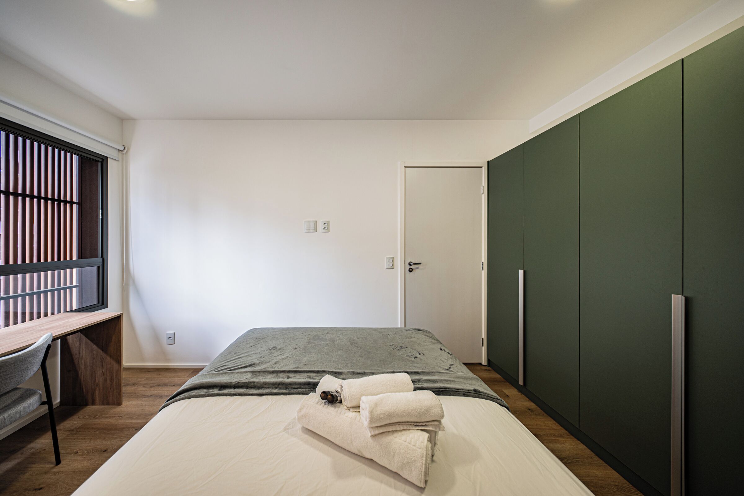 Une chambre à coucher avec un lit, un bureau et une armoire.