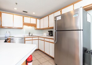 A modern kitchen with white cabinets, stainless steel appliances, and a built-in oven. - Phoenix Viii 81505 1 Bedroom Condo (Orange Beach)