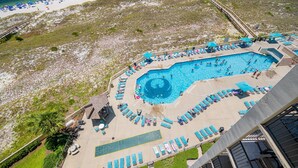 An aerial view of a resort with a large swimming pool, sun loungers, and a boardwalk. - Phoenix Vii 7712 3 Bedroom Condo (Orange Beach)