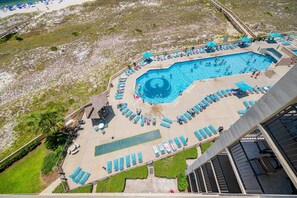 Ein Luftbild eines Resorts mit großem Schwimmbad, Liegestühlen und einem Steg.