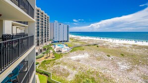 A beachfront hotel with multiple balconies, a pool, and a beach view. - Phoenix Vii 7712 3 Bedroom Condo (Orange Beach)