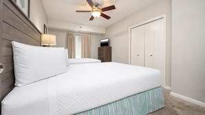 A bedroom with a bed, a ceiling fan, a TV, and a wardrobe. - Phoenix Viii 8306 3 Bedroom Condo (Orange Beach)