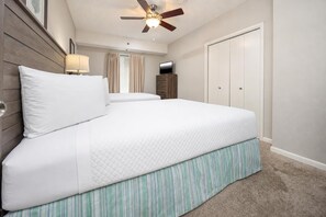 A bedroom with a bed, a ceiling fan, a TV, and a wardrobe. - Phoenix Viii 8306 3 Bedroom Condo (Orange Beach)