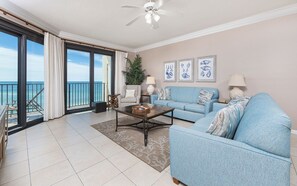 Ein Wohnzimmer mit einer Couch, einem Couchtisch und Meerblick durch große Fenster.