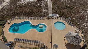 A pool area with multiple pools, sun loungers, and a central fountain. - Phoenix Viii 81003 3 Bedroom Condo (Orange Beach)