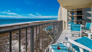 A balcony with a view of the beach, outdoor seating, and a pool area. - Phoenix Viii 8701 3 Bedroom Condo (Orange Beach)
