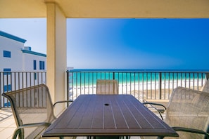 A balcony with a table and chairs overlooking a beach. - Phoenix Viii 81206 3 Bedroom Condo (Orange Beach)