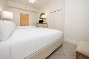 A bedroom with two beds, a dresser, a mirror, a wardrobe, and a chair. - Phoenix Viii 8106 3 Bedroom Condo (Orange Beach)