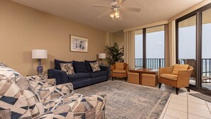 A living room with a sofa, armchairs, a coffee table, and a balcony with a view. - Phoenix Viii 81103 3 Bedroom Condo (Orange Beach)