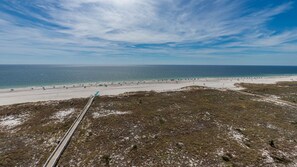 Eine Küstenlandschaft mit Strand, blauem Himmel und einem Gleis.