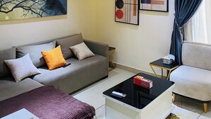 Ein modernes Wohnzimmer mit einer Couch, einem Couchtisch, einem Fernseher und Kunstwerken an den Wänden.