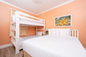 A room with a bunk bed, a single bed, and a painting on the wall. - Phoenix Vii 71205 3 Bedroom Condo (Orange Beach)