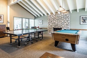 A billiards room with a pool table, a ping pong table, and a stone fireplace. - Cozy Ski Retreat! 2BR/2BA | Walk to Canyon Lodge! (Mammoth Lakes)