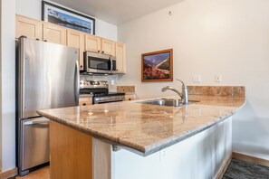 A kitchen with a stainless steel refrigerator, microwave, oven, and sink. - Juniper Springs Gem with Panoramic Mountain Views! (Mammoth Lakes)