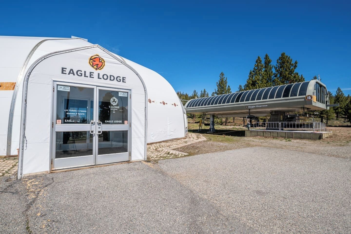 A white building with a curved roof labeled 'EAGLE LODGE' and a covered walkway.