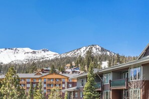 A hotel with multiple floors, balconies, and a mountainous backdrop. - Juniper Springs Gem with Panoramic Mountain Views! (Mammoth Lakes)